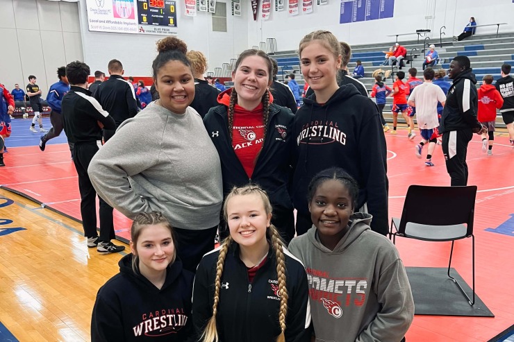 Cardinal CSD's First Girls Wrestling Team posing together in a gym.